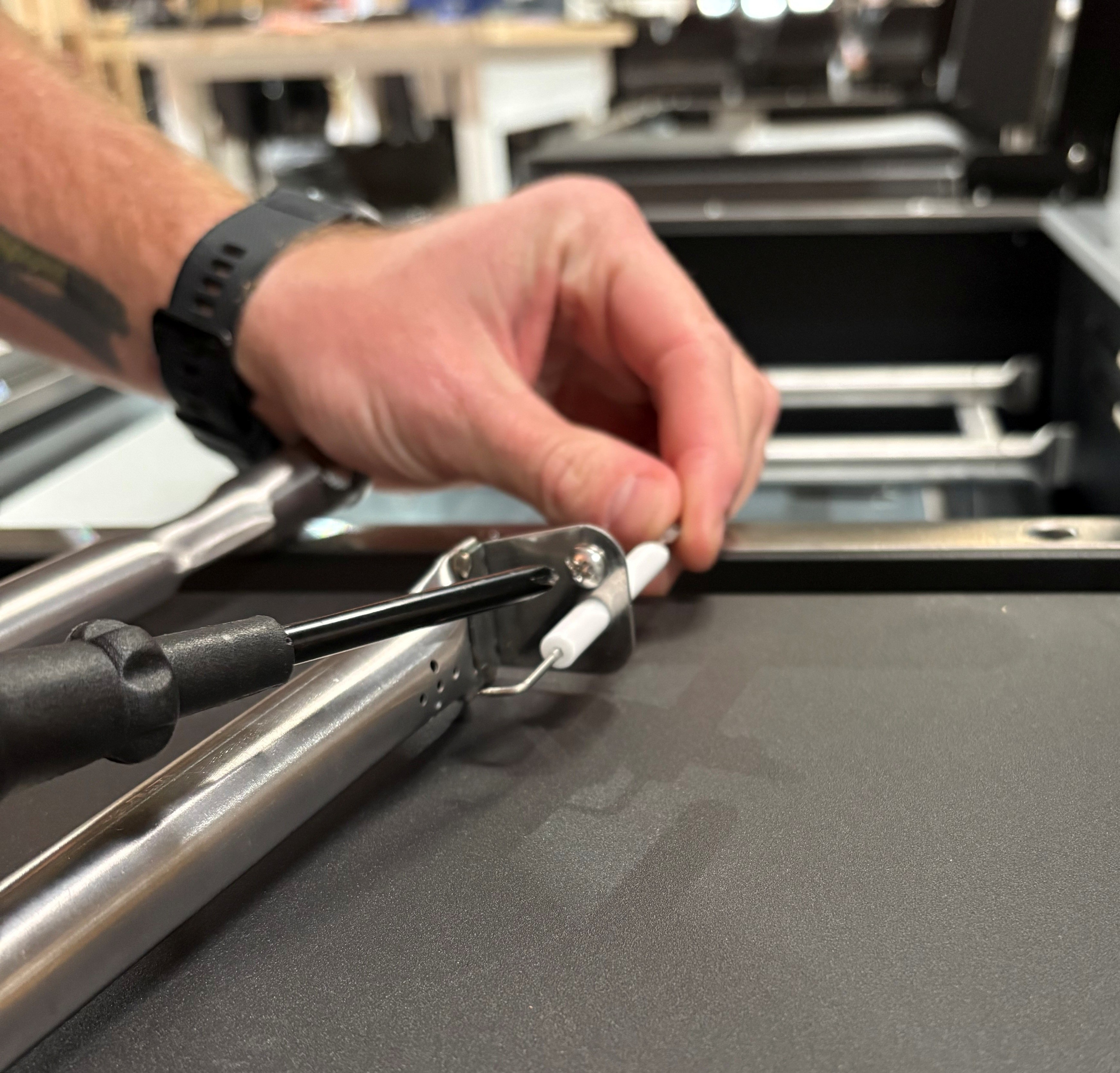 Image showing the removal of the screw while holding the ignitor in place.