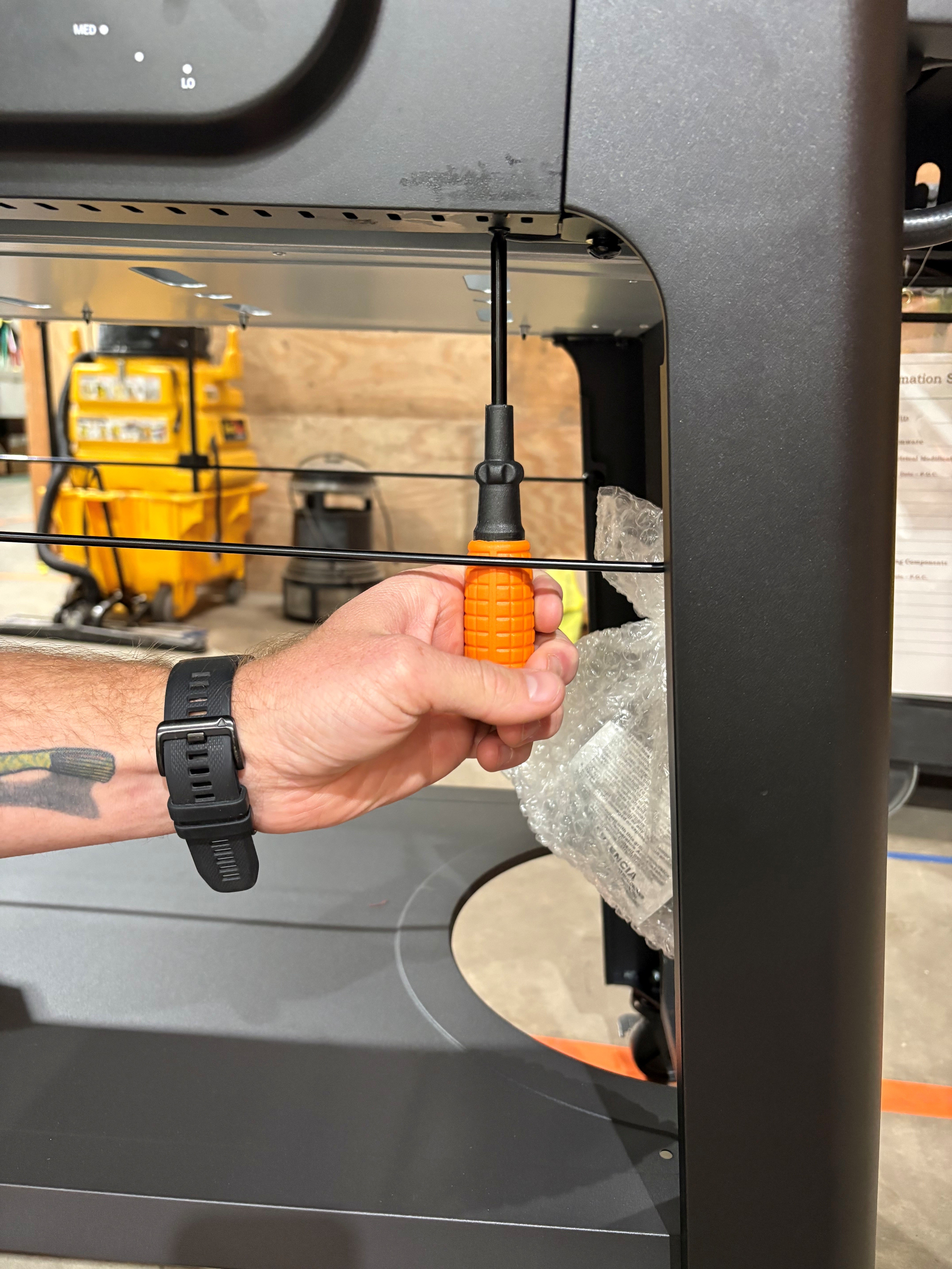 Image showing hand with a screwdriver removing screws attached to the front plate.