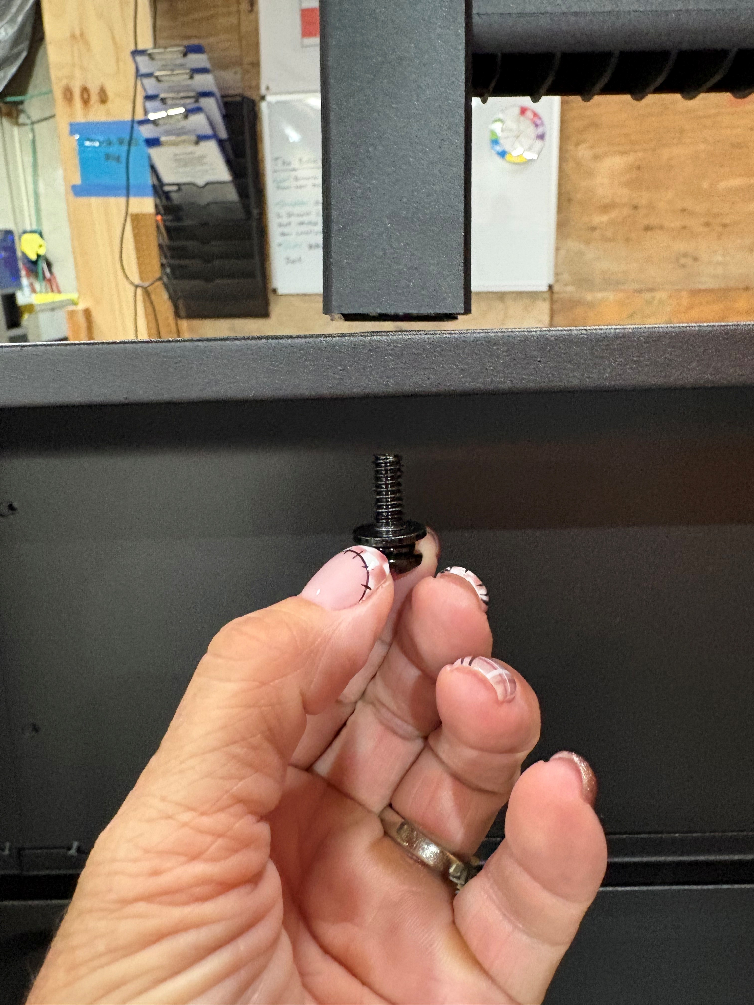 Image of screw that needs to be removed that is located on the inside of the lid.